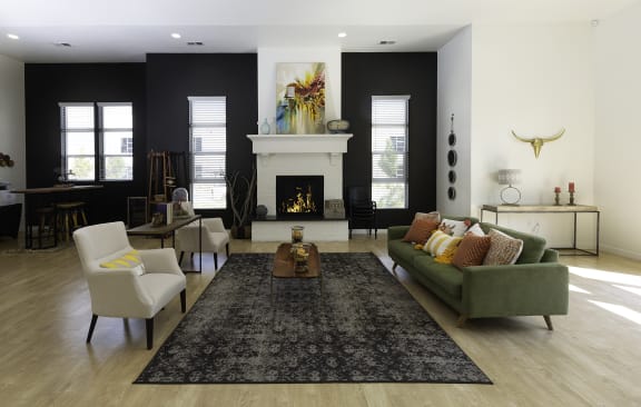 a living room with a green couch and two white chairs in front of a fireplace