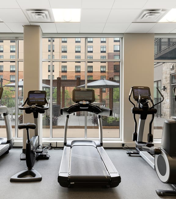 a gym with cardio machines and a view of the window