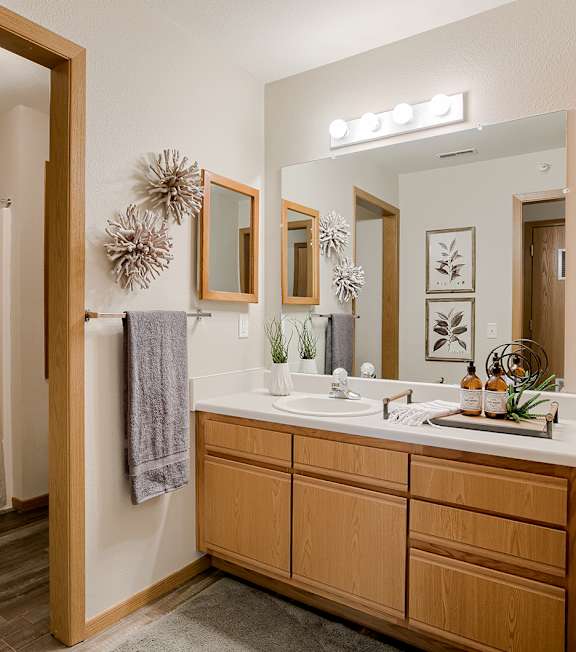 A bathroom with a wooden vanity and a shower with a curtain.
