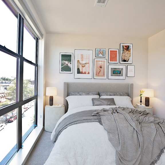 A bedroom with a large bed and a view of the city.