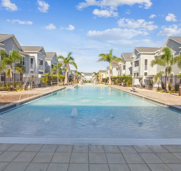 a large swimming pool with apartments in the background  at Palm Grove, Ellenton, FL, 34222