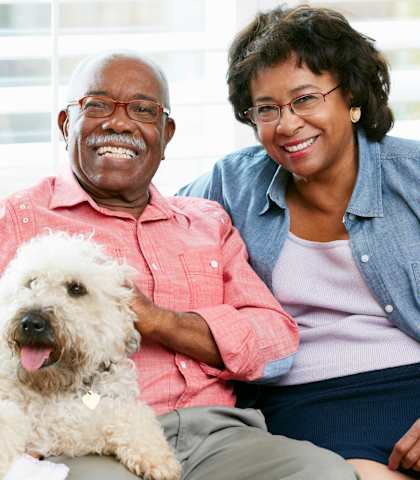 Older couple sitting with a dog at Sweetwater Terraces Apartments, Duluth, Georgia
