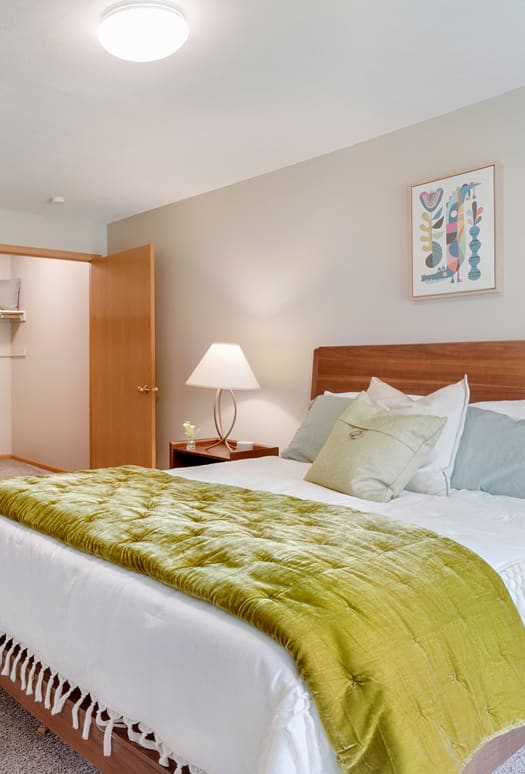 a bedroom with a white bed and a green blanket