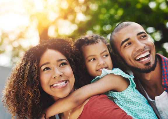 A family of three is enjoying a sunny day outdoors.
