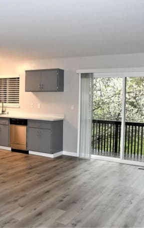 an empty living room with a sliding glass door to a balcony at Trailhead Apartments at Tam Junction, Mill Valley, CA 94941