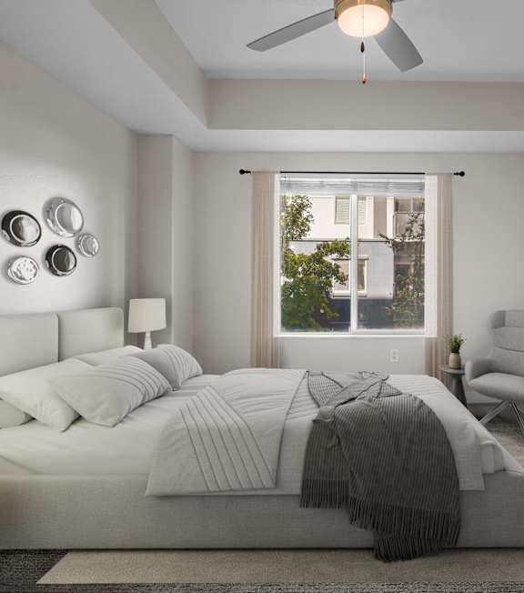 A bedroom with a large bed, a chair, and a painting on the wall.