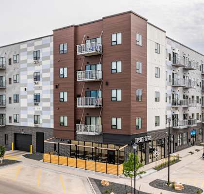 a large apartment building on the corner of a city street at Northern Lights a Lifestyle-Driven Community, North Dakota