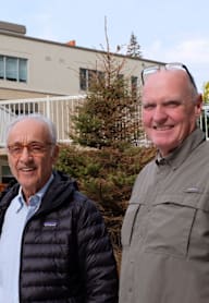 three men posing for a picture in front of a house
