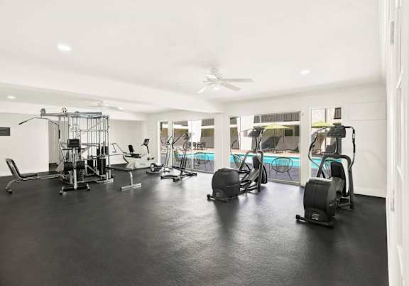 A spacious gym with a variety of equipment including treadmills, stationary bikes, and weight machines. at Bonnie Brae Apartments, California