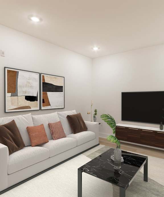 A living room with a white couch, a black coffee table, and a flat screen TV.
