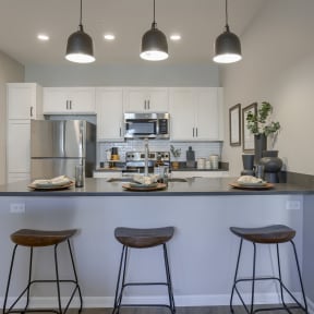 a kitchen with a center island with three stools