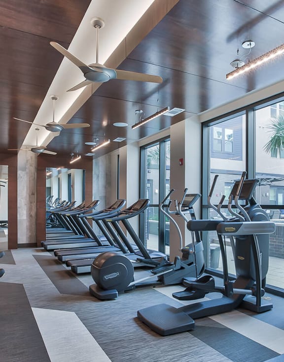 a room filled with lots of cardio equipment and weights