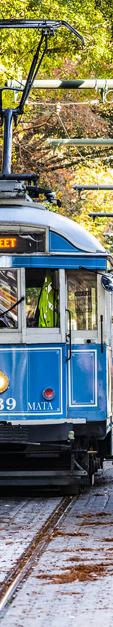 a blue trolley car on a city street