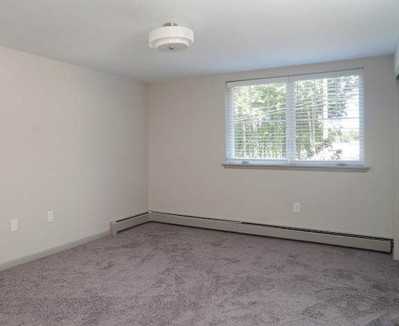 an empty living room with a window and carpet  at Enclave West Hartford / Parc West, West Hartford