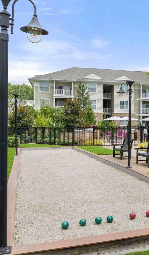 A bocce ball court in front of apartment buildings.