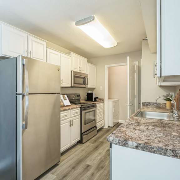 A kitchen with a granite countertop and stainless steel appliances.
