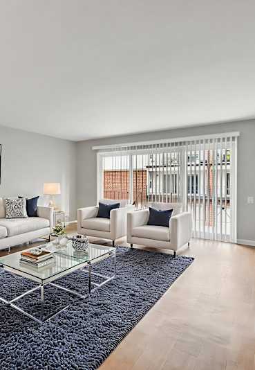 A modern living room with a white sofa set and a glass coffee table.