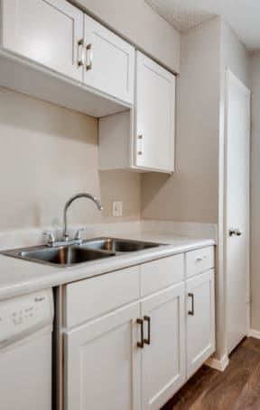 an empty kitchen with white cabinets and a sink