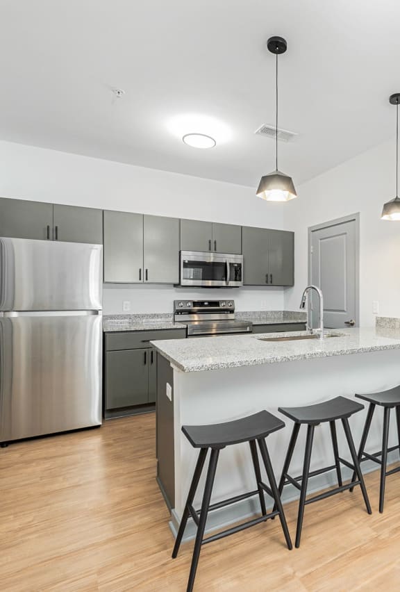 a kitchen with a large island with three bar stools