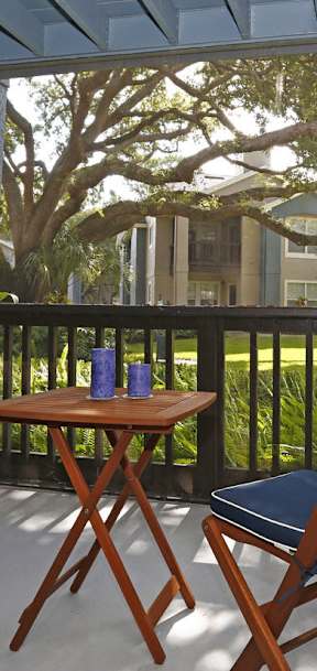 a patio with two chairs and a table on a balcony