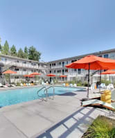 The Post Apartments pool area with umbrellas and lounge seating at THE POST Apartments, PLEASANT HILL , CA