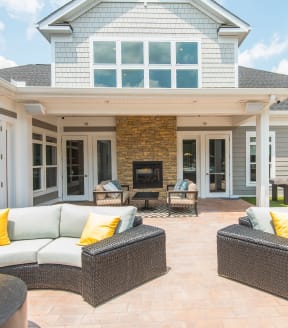 a patio with wicker furniture and a fireplace