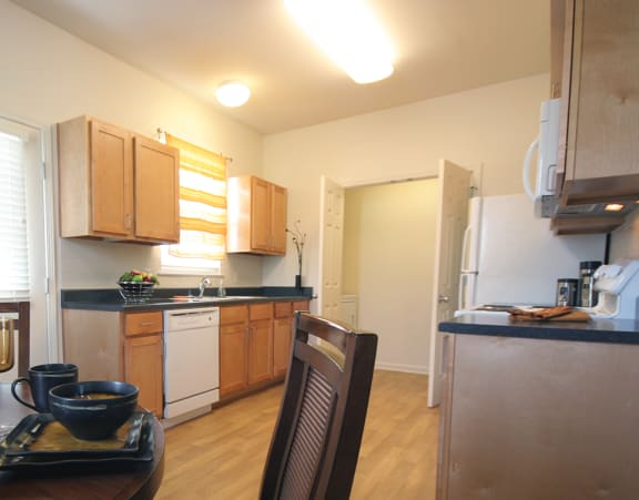 a living room with a couch and a dining table and a refrigerator surrounded by cabinets