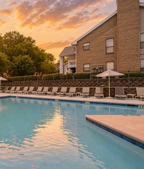 A large outdoor swimming pool with a fountain in the middle.
