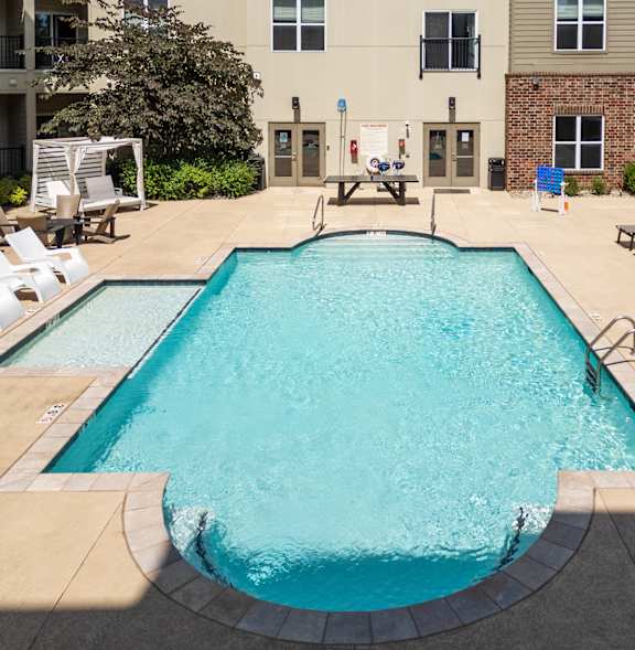 A large rectangular pool with a concrete floor and a concrete wall surrounding it.