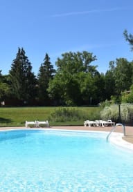 a swimming pool with a fence and chairs around it