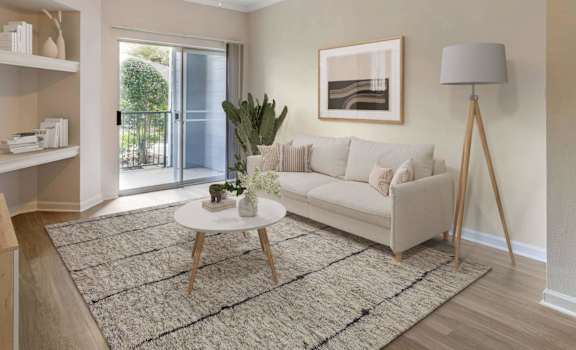 A living room with a white couch, a rug, and a ceiling fan.