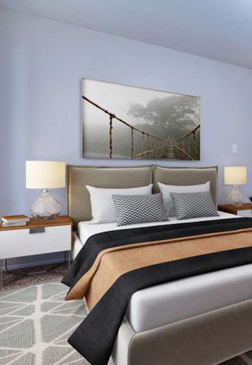 A bedroom with a large bed and a painting on the wall.