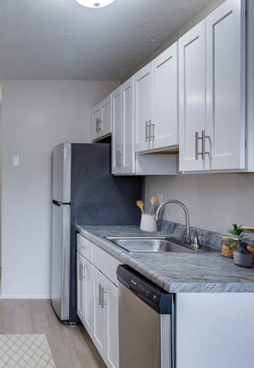 A kitchen with black appliances and white cabinets.