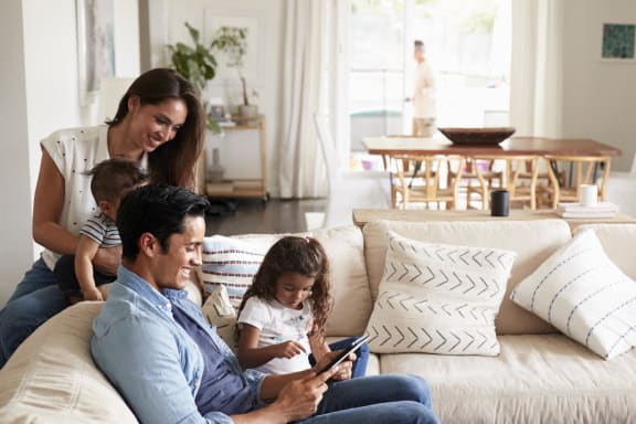 a family sitting on the couch looking at a tabletat Upper Post Flats, Fort Snelling, MN