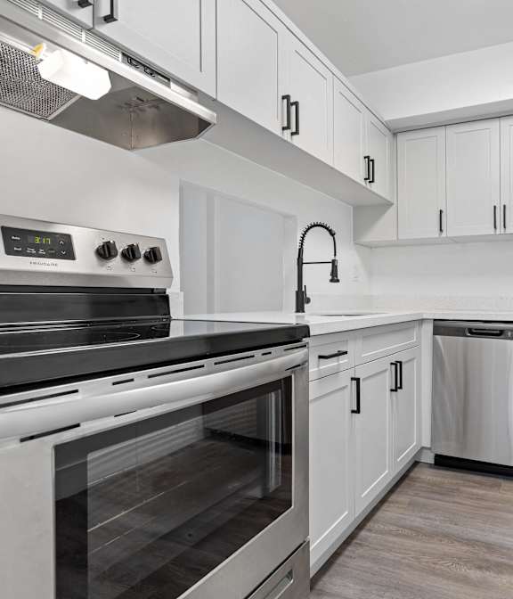 A modern kitchen with stainless steel appliances and white cabinetry.