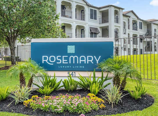 A sign for Rosemary Luxury Living in front of a building.