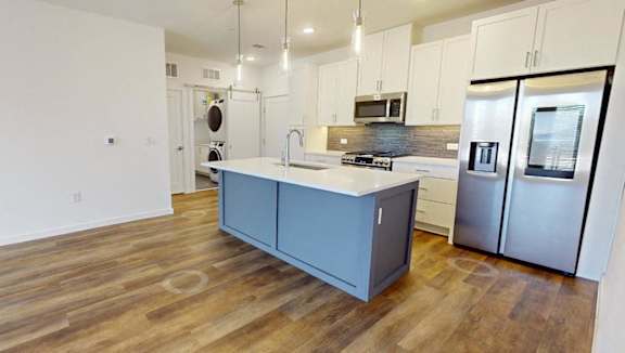 A kitchen with a wooden floor and white walls.