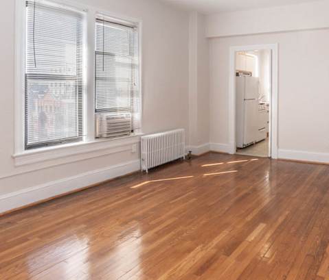 a living room with hardwood floors and a large window