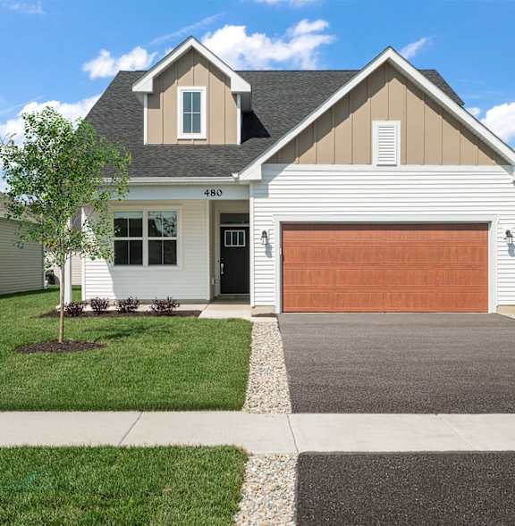 A house with a green garage door and a brown driveway.