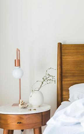 A bed with white pillows and a wooden headboard.