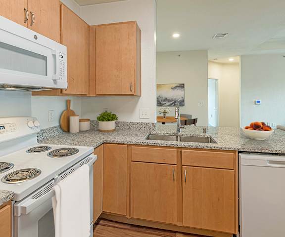 a kitchen with white appliances and granite counter tops