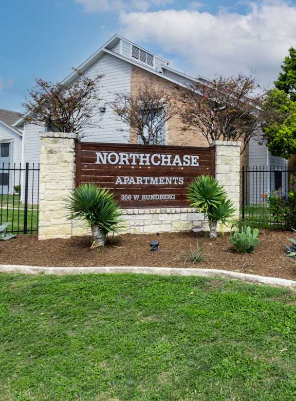 The image shows a sign for Northchase Apartments in front of a building.