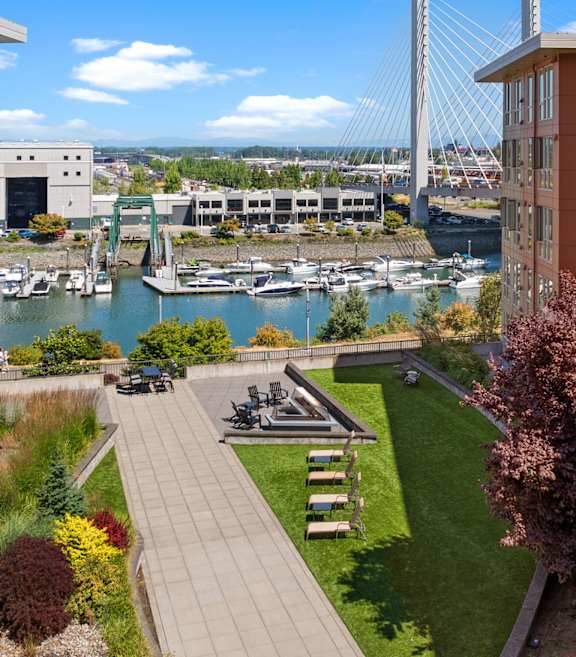 A view of a cityscape from a balcony with a bridge in the background.