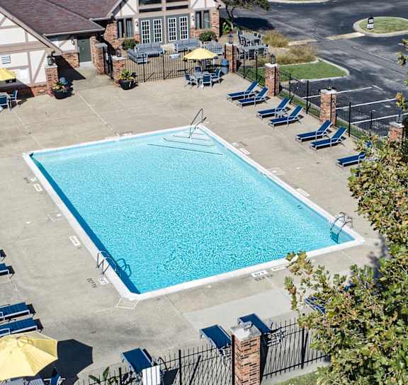 a a swimming pool in front of a clubhouse with lounge chairs around it The Timbers Apartments, Evansville, 47715