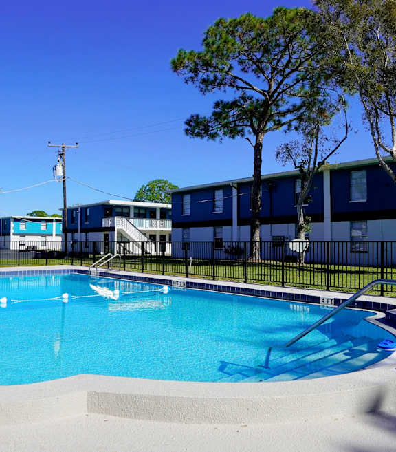A large outdoor swimming pool with a blue sky in the background.
