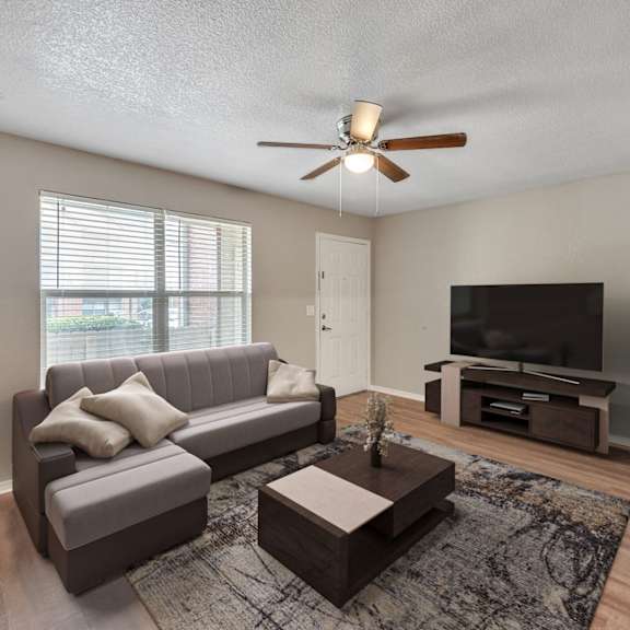 the living room of an empty house with a ceiling fan