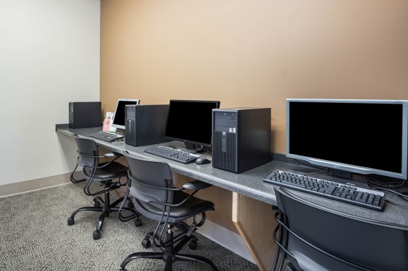 a computer room with monitors and computers on a table