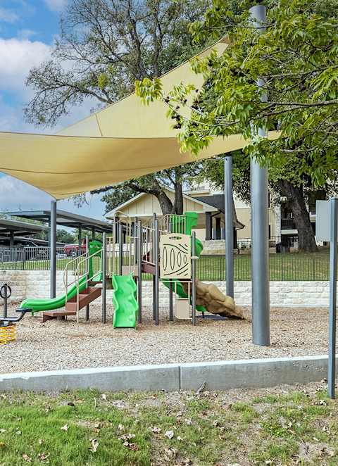 a playground with a swing set and a canopy