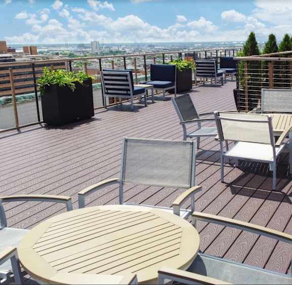Tables and chairs set up on the Commownealth rooftop deck with panoramic views of downtown Philadelphia