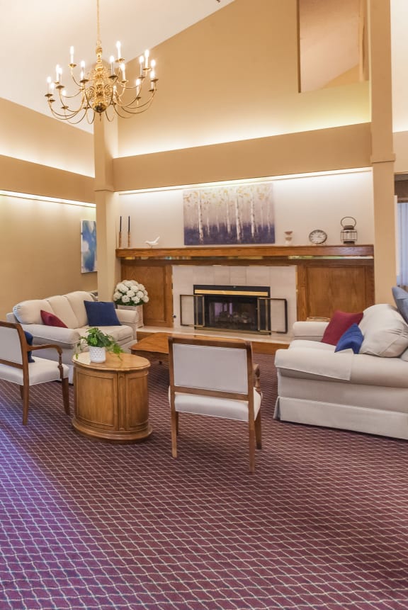 a living room with white couches and a coffee table at River Commons Senior Living, California